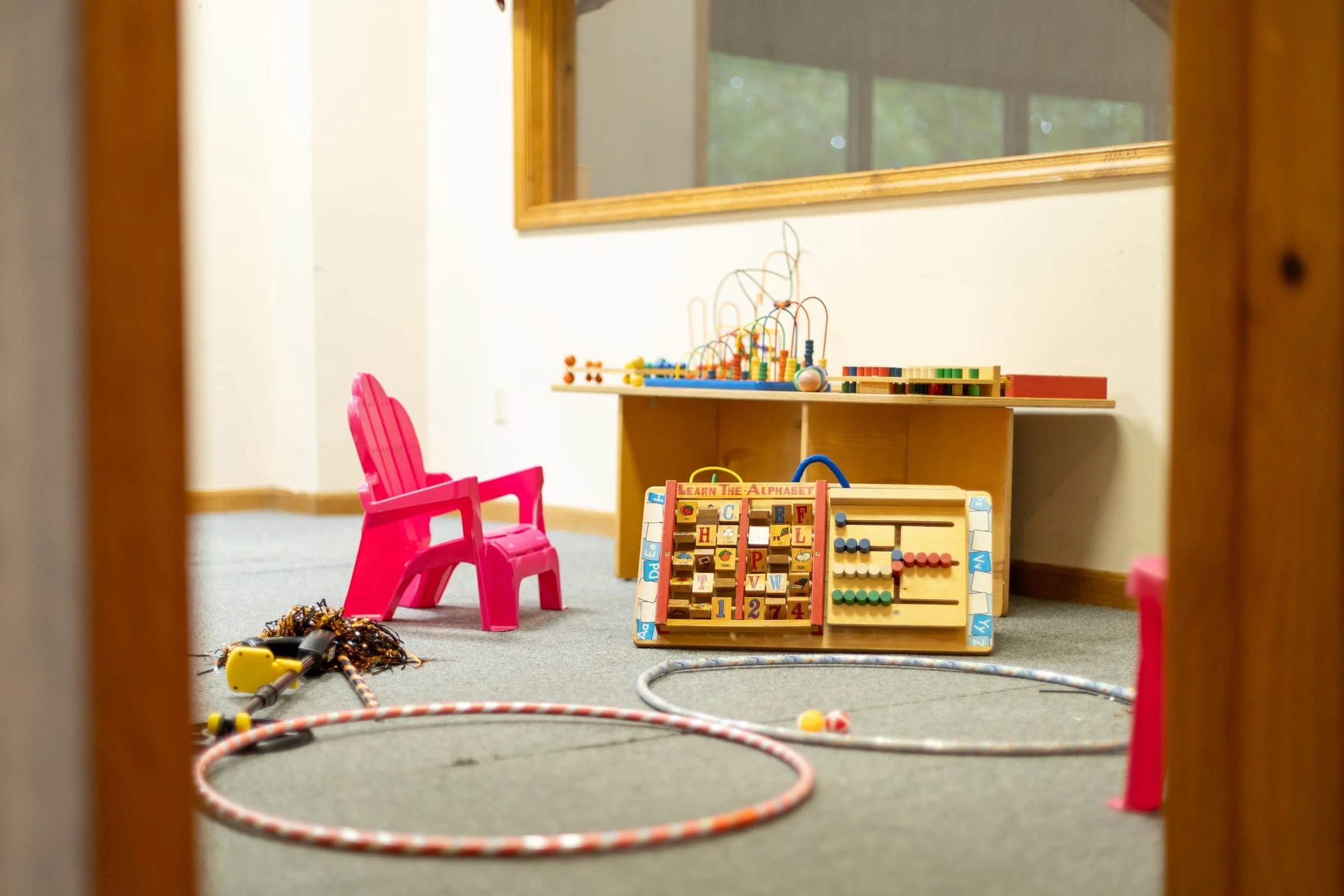 Kids corner with toy chair, bead maze and hula hoops